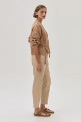 Cárdigan color camel de tejido de punto con trenzas en las mangas y cierre frontal con botones.