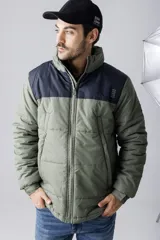 Campera puffer bicolor en verde militar y azul marino, con cierre frontal y cuello alto.