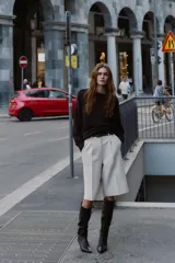 Bermuda larga color marrón oscuro, tiro medio, con pinzas frontales y cinturón de textura animal print plateado.