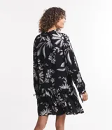 Vestido corto de viscosa con estampado floral en blanco y negro, escote en V, mangas largas con lazo en los puños y volados en el ruedo.