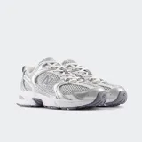 Championes New Balance 530 de estilo retro, color blanco y plateado con detalles en gris. Cuenta con capellada de malla transpirable, detalles sintéticos metalizados, entresuela ABZORB acolchada para mayor absorción de impactos y suela de goma.