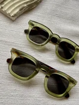 Lentes de sol con armazón geométrico de acetato verde translúcido y patrón carey en el interior, con cristales oscuros y protección UV400.