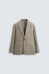 Blazer de corte relajado confeccionado en lino con efecto lavado. Presenta cuello con solapas de pico, cierre frontal de un botón, manga larga y bolsillos con solapa en la parte frontal.
