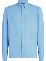 Camisa Tommy Hilfiger de manga larga color celeste con micro estampado de puntos, cuello con botones y cierre frontal. Incluye el logo de Tommy Hilfiger bordado en el pecho.