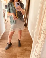 Minifalda tejida en lurex plateado, con flecos en el ruedo y cintura elástica.