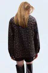 Campera de sarga de algodón con estampado animal print, cuello abierto, cierre frontal con botones y bolsillos delanteros de parche con solapa. Presenta hombros levemente caídos y puños abotonados.