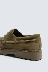 Zapato tipo náutico color verde oliva. Capellada de cuero serraje, con cordones y suela track. Marca Mango Man.