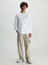 Remera blanca de manga larga Calvin Klein Jeans, confeccionada en algodón orgánico. Presenta cuello redondo, puños de canalé y un estampado con el logo de la marca en el pecho.