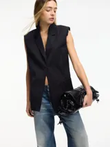 Chaleco negro con cuello solapa, sin mangas y con hombreras.