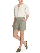 Short de tiro alto confeccionado en lino, con diseño de pinzas frontales, bolsillos laterales y detalle de hebillas ajustables en la cintura. Presenta un ruedo con dobladillo y cierre frontal.