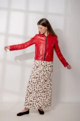 Chaqueta de cuero ovino en color rojo, con corte recto, cuello clásico, hombros definidos y cierre frontal con cremallera metálica. Presenta bolsillos laterales con cierre y puños con cremallera.