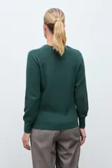 Sweater de punto color verde inglés, con cuello redondo y diseño de textura geométrica en relieve en la parte frontal.