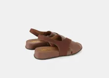 Sandalias planas color marrón con tiras cruzadas en el empeine, talón con elástico y plantilla acolchada.