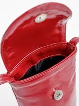 Porta celular tipo bandolera de cuero charol rojo, de diseño vertical con solapa decorada con tachas metálicas plateadas en forma de arco y correa larga fina.