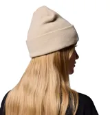 Gorro tipo beanie de tejido grueso color beige, con diseño de punto acanalado y vuelta en el borde. Presenta un parche cuadrado en el frente con el logo de la marca Columbia.