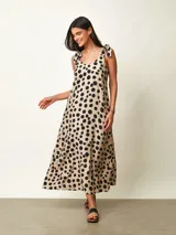 Vestido midi negro con estampado gráfico en blanco, de corte amplio y escote redondo con tirantes anudados en los hombros.