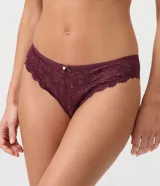 Bombacha bikini Lov confeccionada en encaje rústico con textura floral, de laterales anchos y cintura elástica con aplique de moño y dije colgante.