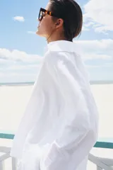 Camisa blanca de la colección ZARA Woman, confeccionada en hilatura con lino, con escote en pico, manga larga con puño ancho y detalles desflecados en cuello y bajo.