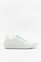 Zapatilla de estilo minimalista tipo barefoot, confeccionada en tejido textil transpirable de color blanco. Presenta suela plana y flexible, cordones al tono con detalles en color menta y tirador en el talón.