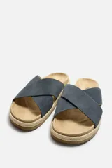 Sandalia plana color beige con dos tiras anchas cruzadas en el empeine, plantilla anatómica y suela forrada en yute.