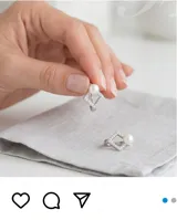 Aros tipo argolla con diseño geométrico en forma de rombo, engastados con pequeñas circonias brillantes y rematados con una perla blanca. Fabricados en plata 925.