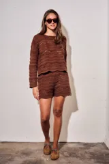 Short tejido de punto con diseño de ondas y calados, color blanco. Presenta cintura elástica acanalada y corte mini.