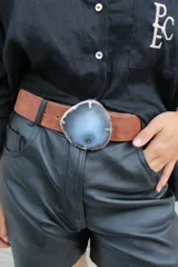 Cinto de cuero azul con hebilla circular de piedra ágata con borde dorado.