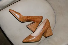 Zapatos de tacón color fucsia con textura croco, punta fina y tacón cuadrado forrado en cuero.