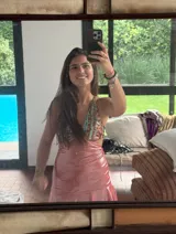 Vestido corto negro con estampado de plumas doradas, escote en V, breteles finos cruzados en la espalda, cut-outs laterales y volado en el ruedo.