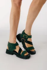 Sandalias con plataforma color verde y negro, con tiras de cuero y hebillas metálicas.