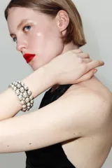 Pulsera rígida de diseño abierto, compuesta por tres hileras de esferas metálicas con acabado plateado envejecido.