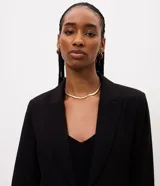 Blazer corto de sastre de la marca Cortelle, color negro, confeccionado en poliéster. Cuenta con cuello con solapa, mangas largas con amarre en los puños, bolsillos delanteros y cierre frontal por cordón ajustable con punteras metálicas.