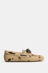 Mocasín de piel con pelo y estampado animal, con detalle de cordones en el empeine y pespuntes decorativos.