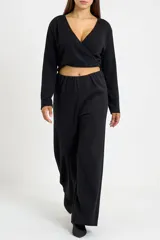 Pantalón tipo palazzo de tiro alto, color negro, con diseño de corte amplio y fluido. Confeccionado en tejido de poliéster con un sutil acabado brillante.