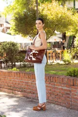 Sandalias de cuero color marrón, con dos tiras anchas sobre el empeine, pulsera con hebilla al tobillo y tacón bloque.