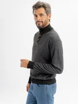 Buzo de punto color marrón oscuro con cuello alto y cierre frontal parcial de cuatro botones. Presenta una textura jaspeada y puños acanalados.
