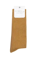 Calcetines de caña alta con acabado brillante y textura acanalada. Presentan un diseño en tono mostaza con destellos plateados.