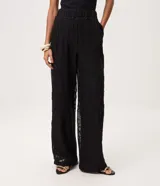 Pantalón de tricot negro con corte wide leg, transparencia delicada y bordado abstracto en relieve. Cuenta con cintura elástica y caída fluida.