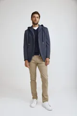 Blazer sport color gris claro con capucha integrada y cordones ajustables. Presenta solapas clásicas, cierre frontal con botones y bolsillos laterales de parche.