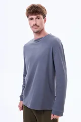 Buzo de manga larga con textura tipo waffle, cuello redondo y corte holgado.