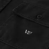 Camisa negra de manga larga con dos bolsillos frontales con solapa y cierre de botón. Presenta un logo bordado en el bolsillo izquierdo.