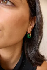 Aros dorados con dije circular de piedra natural negra.