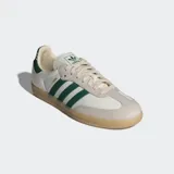 Championes Adidas modelo Samba OG, con diseño clásico de perfil bajo. Presentan una base de cuero color crema con superposiciones de gamuza gris en la puntera y los ojales. Incluyen las icónicas tres rayas laterales y el detalle en el talón en color verde oscuro, con suela de goma color caramelo.