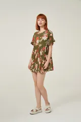 Vestido corto de viscosa con estampado floral en tonos verdes, rojos y blancos. Presenta un diseño holgado con cuello a la base y mangas cortas con volados en los extremos.