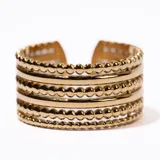 Anillo dorado con múltiples bandas horizontales, algunas lisas y otras con pequeñas esferas.