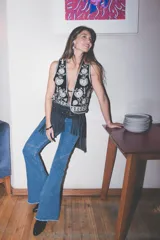 Jeans de corte flare y tiro medio, en color azul, con diseño acampanado y detalles de costuras en las piernas.