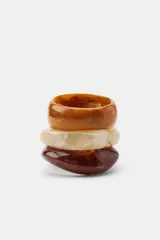 Pack de tres pulseras rígidas de resina en tonos tostado, marrón y beige, con diseño texturizado estilo carey y formas geométricas irregulares.