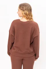 Sweater de morley felpa con cuello redondo a la base, mangas largas holgadas y corte recto.