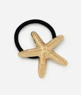 Elástico para el pelo negro con aplicación de estrella de mar metalizada en tono dorado claro, con textura martillada.