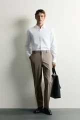 Camisa de corte slim fit, color celeste, con cuello italiano y manga larga con puños abotonados. Presenta un tejido con textura y cierre frontal de botones.